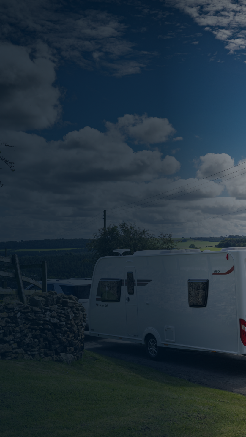 A car pulling a camper trailer on a road in the countryside. 